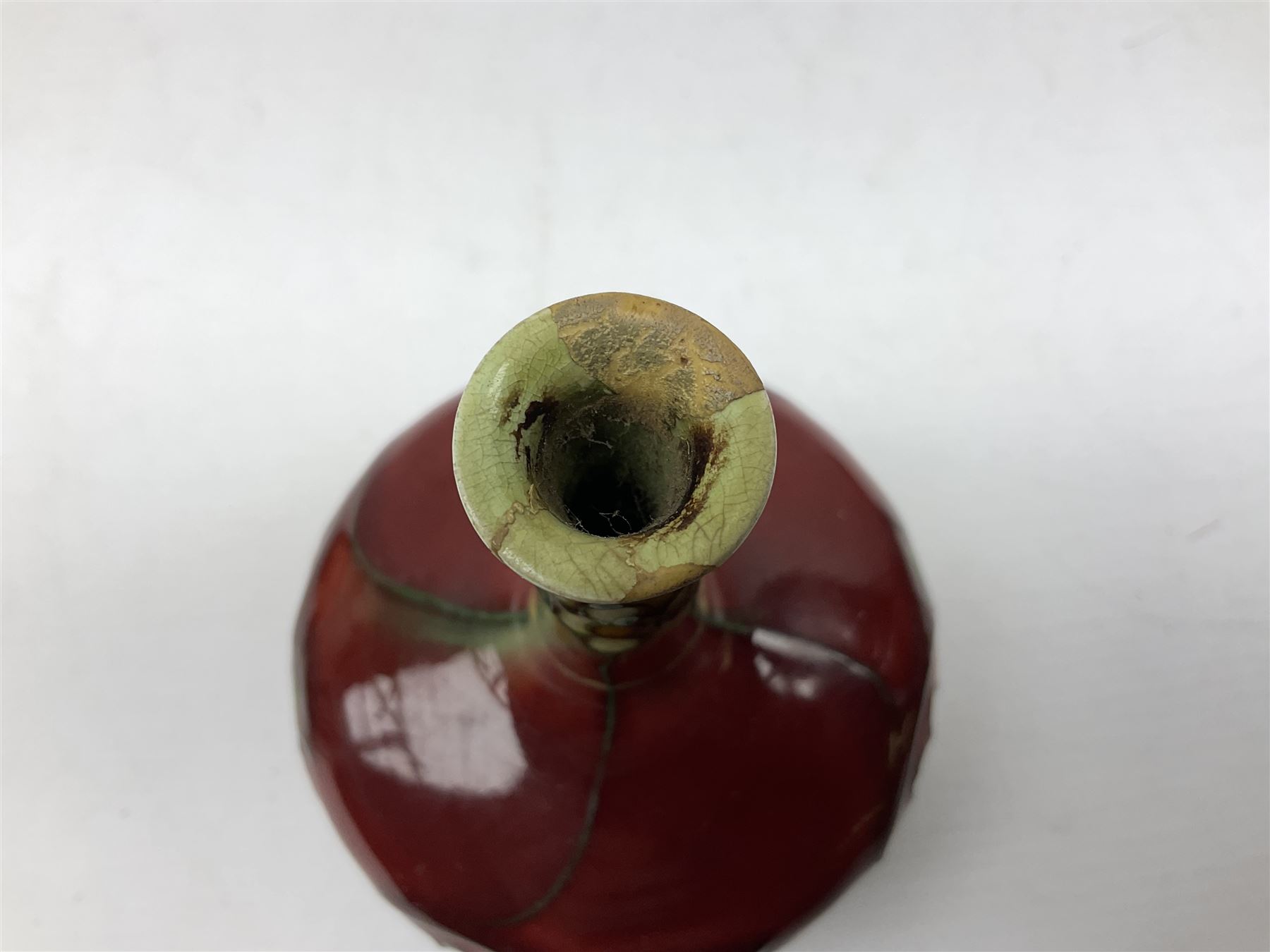 Three Minton Secessionist vases, with tube-lined stylised flower decoration, two upon a red ground and third upon a purple ground, all with printed mark to base 'Minton Ltd, No. 33', H13cm