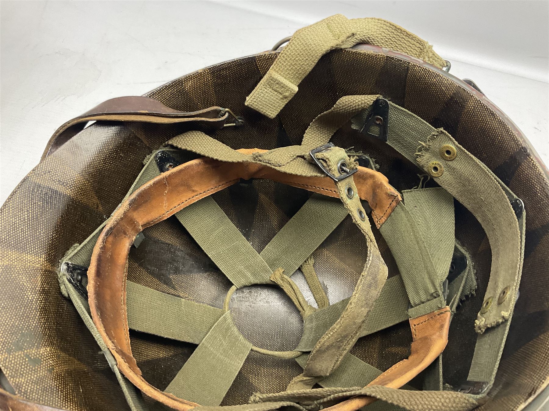 American first type paratrooper helmet with post-WW2 strap and D-rings and later 1944 liner bearing Firestone Tyre and Rubber Company mark; green textured finish