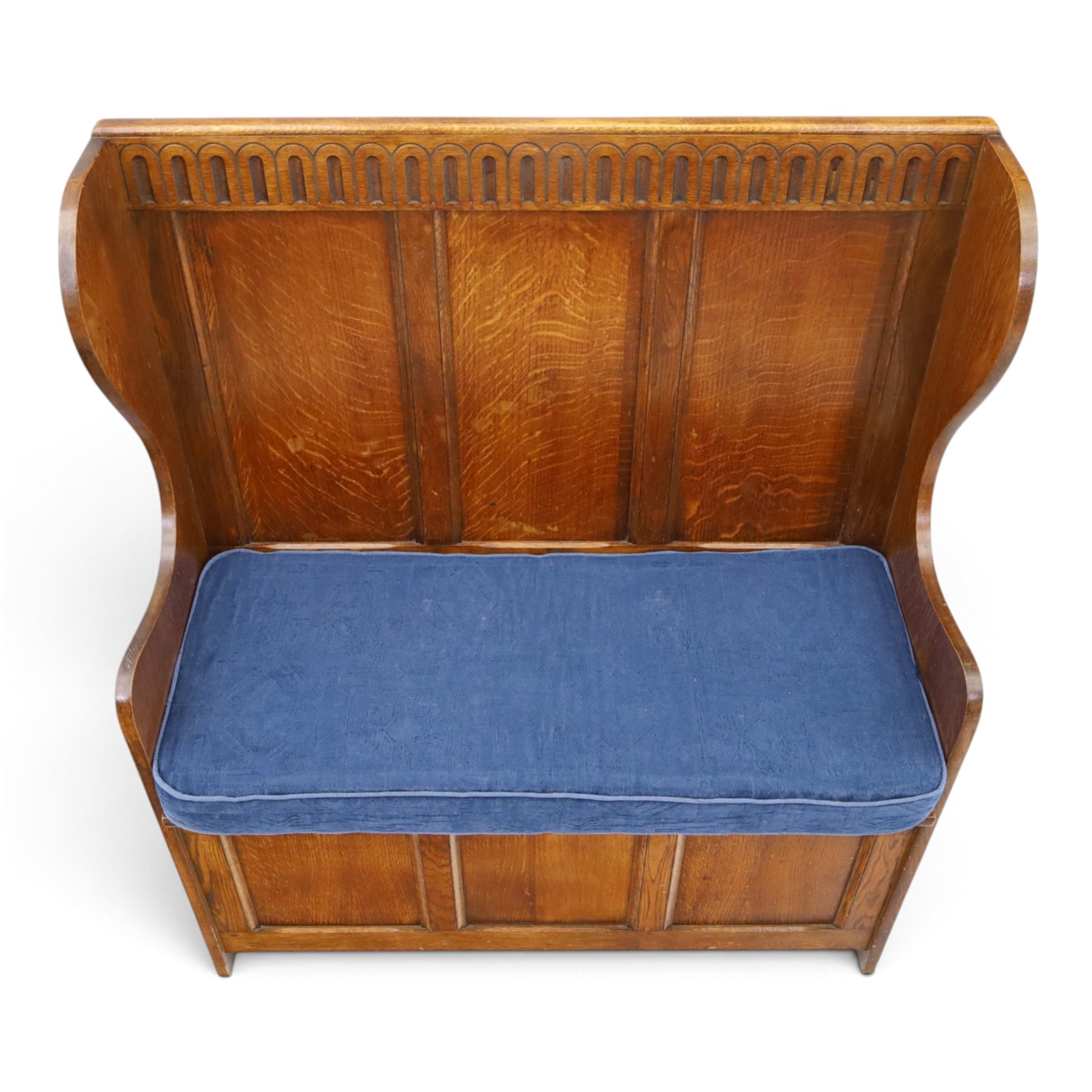 Early 20th century oak box settle, panelled back with arcaded carved rail, swept sides and arms, hinged seat with storage, panelled front
