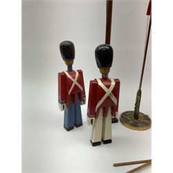 Five Kay Bojesen wooden soldiers, three boxed, two standard bearers with flags, one with gun, four with blue trousers and one white trousers H23cm, along with two table top Danish flags on flagpoles, mahogany flag pole H59.5cm and metal flagpole with a decorated base H39.5cm. 