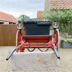 Holland & Holland Tandem Cart - Althorp Spencer Family Estate

A two wheeled tandem cart or cocking cart by Holland & Holland Coach Builders, London, with black painted bodywork, red painted shafts and running gear, red wooden spoked wheels with rubber tyres, green upholstered seating and a rear perforated metal footboard. The cart is fitted with carriage lamp brackets (lamps next lot), green buttoned cushions with leather retaining straps, side louvered body panels, footrests, leaf spring suspension and shafts for horse use. The carriage incorporates an adjustable body position, operated by a lever, allowing the body to be moved forwards or backwards to alter the weight distribution. Formerly owned by the family of Lady Diana Spencer,
Sympathetically conserved by Woods of Fairbourne Carriages Ltd, Kent.

Features:
• Brass maker’s plaque for Holland & Holland Coach Builders, London
• Two wheeled tandem cart
• Black painted body with red painted shafts and running gear
• Red wooden spoked wheels with rubber tyres
• Green upholstered cushions with leather retaining straps
• Adjustable carriage body for weight distribution
• Lever operated adjustment mechanism
• Perforated rear footboard
• Side footrests
• Louvered side panels
• Leaf spring suspension
• Rear opening storage compartment
• Decorative painted armorial motif to rear panel
• Fitted carriage lamps shown, not included in the lot (available as next lot)
• Conserved by Fairbourne Carriages Ltd
• Provenance: The Althorp Attic Sale including The Spencer Carriages, lot 195, 7 July 2010

Dimensions:
Overall length 396 / 198cm
Width 155cm
Height 190cm

Wheel Diameters:
Wheels: 148cm

Seating:
Driving seats: 2
Passenger seats: 2