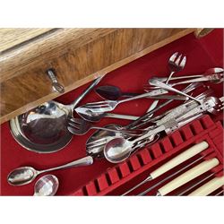 Walker and Hall part canteen of silver plated cutlery, including table knives, dessert knives and carving set, all with ivorine handles and twelve dessert forks, together with a single silver teaspoon and a collection of other silver plated cutlery, all housed within a mid 20th century oak canteen, with two drawers on four straight legs