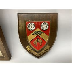 Framed sampler and two armorial plaques 