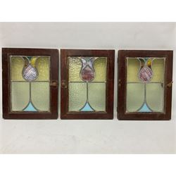 Three 20th century stained glass windows, stylised tulip mounted in a rectangular door with metal handles, with original receipt from 1921, H35.5cm  