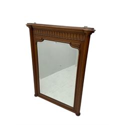 Early 20th century French oak overmantle mirror, projecting cornice with broken foliate carved frieze, shaped rectangular bevelled plate flanked by fluted column uprights