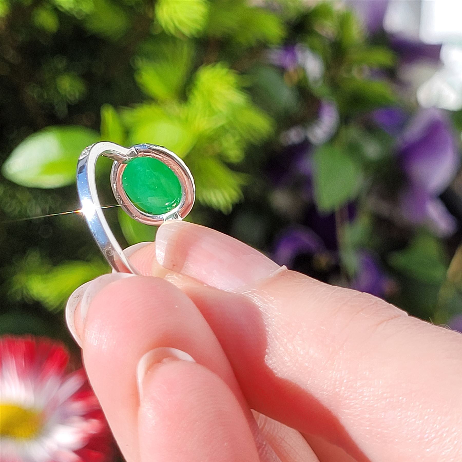 Platinum jadeite and diamond cluster ring, single oval cabochon cut jadeite of 2.20 carat, surrounded by round brilliant cut diamonds and diamond set shoulders, stamped Plat