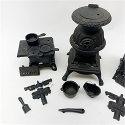 Three miniature cast iron salesman sample stoves, together with a miniature cast iron pot belly stove. 