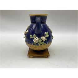 Minton majolica vase, the squat body with twin handles, with part osier moulding and applied Spring flowers against a cobalt blue ground, upon integral square base, impressed beneath Minton 1316, H16.5cm