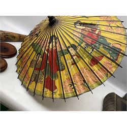 Three carved oriental wood stands, with pierced decoration, and two oriental parasols