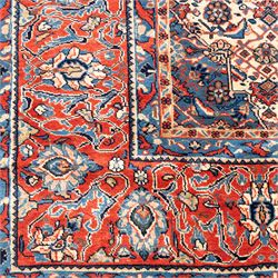 Large West Persian Bidjar hand-knotted carpet, deep indigo field with central medallion with pendants issuing an all-over design of scrolling vines, palmettes, and floral sprays, within conforming spandrels, enclosed a broad madder red palmette, and vine border framed by guard stripes, in a palette, of indigo, madder red and ivory tones, with cotton fringe ends 