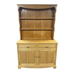 Unicornman - light oak dresser, the shaped cresting rail carved with Yorkshire rose over two heights plate rack, the panelled lower section fitted with two drawers and two cupboards, carved with unicorn signature, by Geoff Gell, Coxwold
