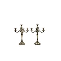 Pair of four branch candelabra, urn-shaped nozzles raised upon scroll branches supported from tapering central stem, with a stepped circular base, H40cm