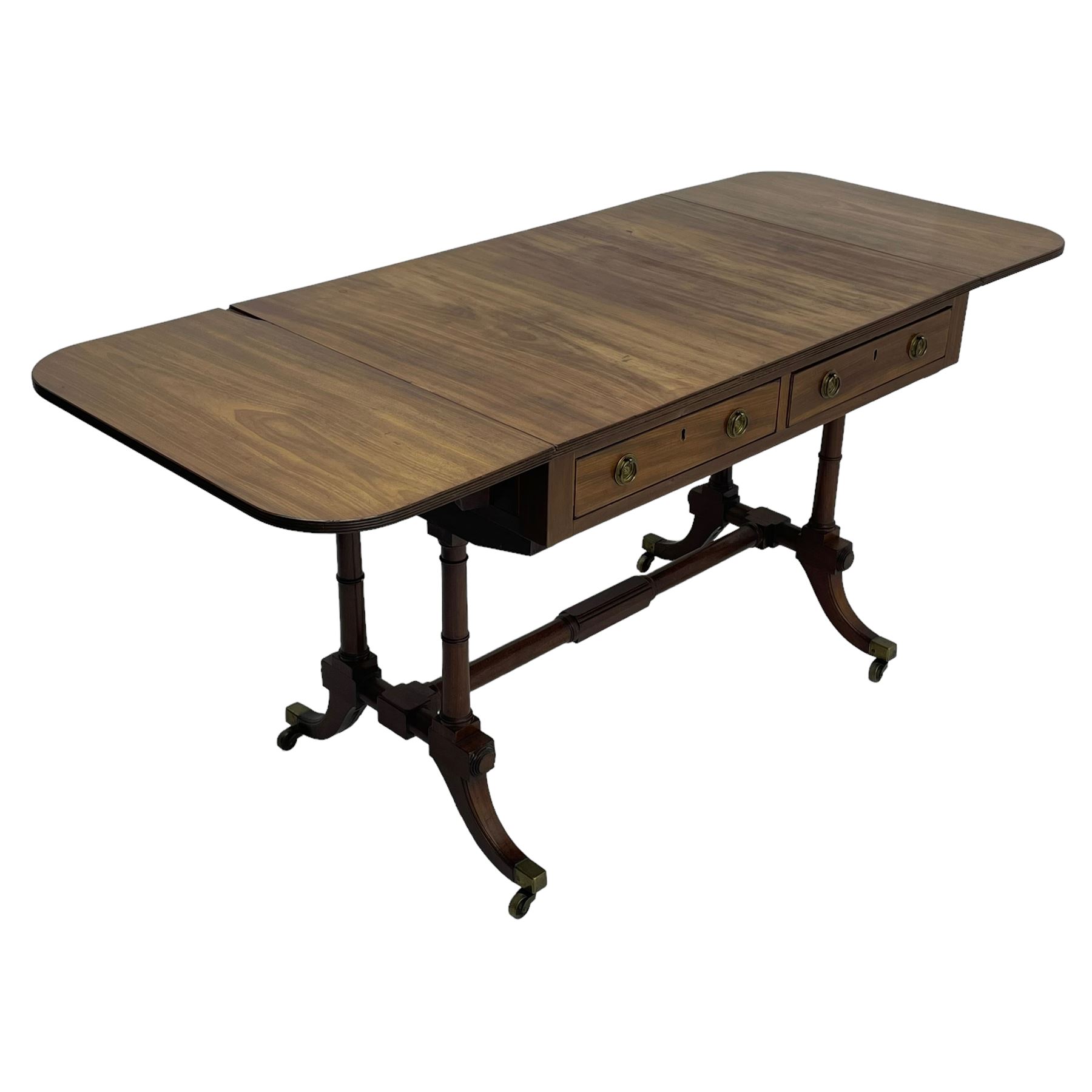 George III mahogany sofa table, rectangular drop-leaf top with reed moulded edge and rounded corners, fitted with two frieze drawers and two opposing false drawers, quadruple collar turned pillar supports on turned and block platforms, splayed and moulded supports with brass cups and castors 