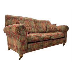 Duresta - 'Beaminster' grande two-seat sofa, traditional shape with rolled arms, upholstered in 'Althorp' russet and stone floral pattern fabric, on turned feet with brass castors
