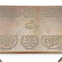 Arts and Crafts oak table, the rectangular top decorated with incised and carved scrolling foliage panels, the centre carved with a shield-shaped cartouche dated 1905, over a simple frieze with matching carved decoration to the front, on straight tapering legs