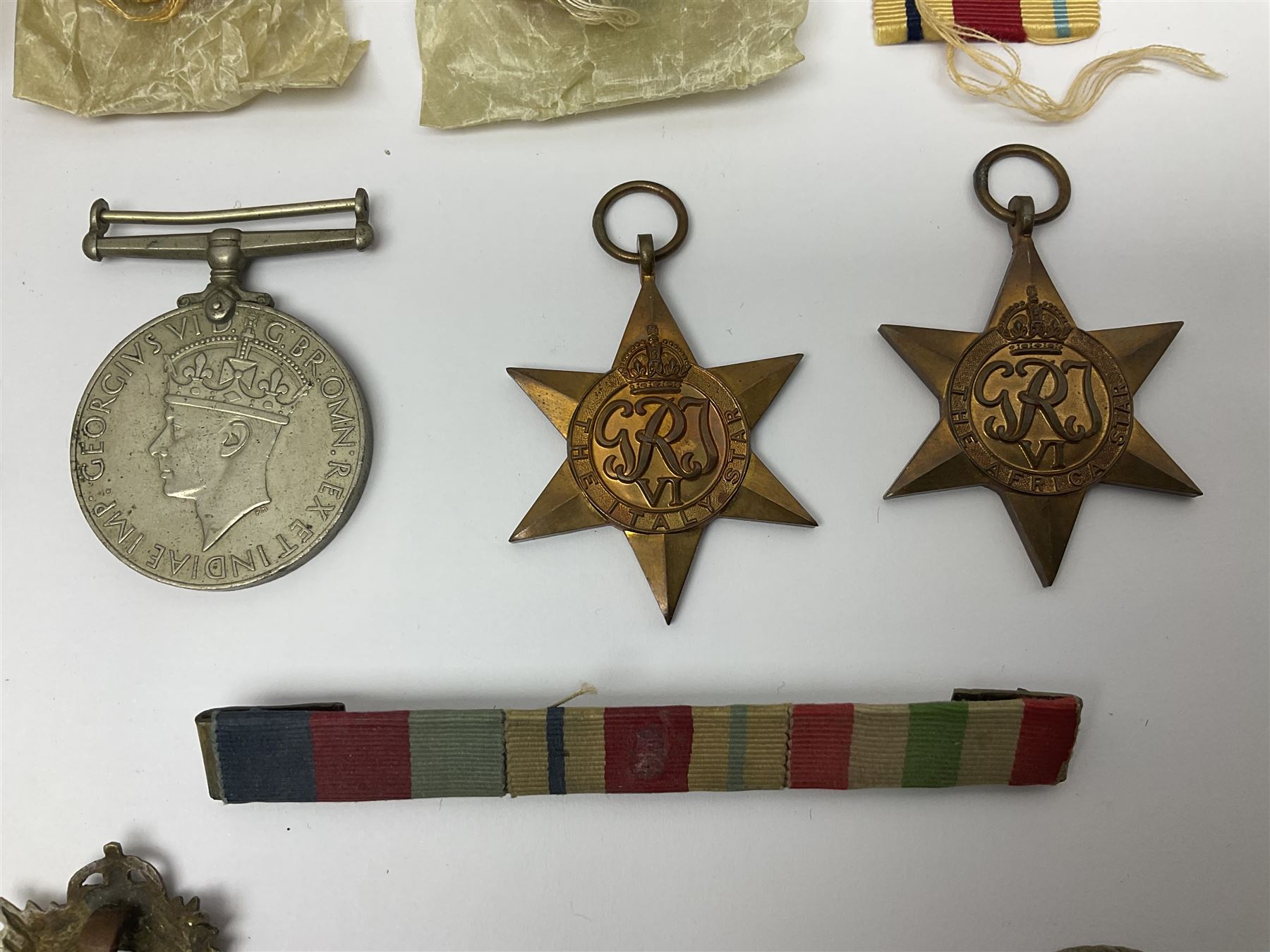 WWII group of three medals comprising 1939-45 War Medal and Italy and Africa Stars in issue box; dog tags for 282894 W. Wilkinson with framed photograph in uniform; and small quantity of cloth and metal badges including RAOC cap badge