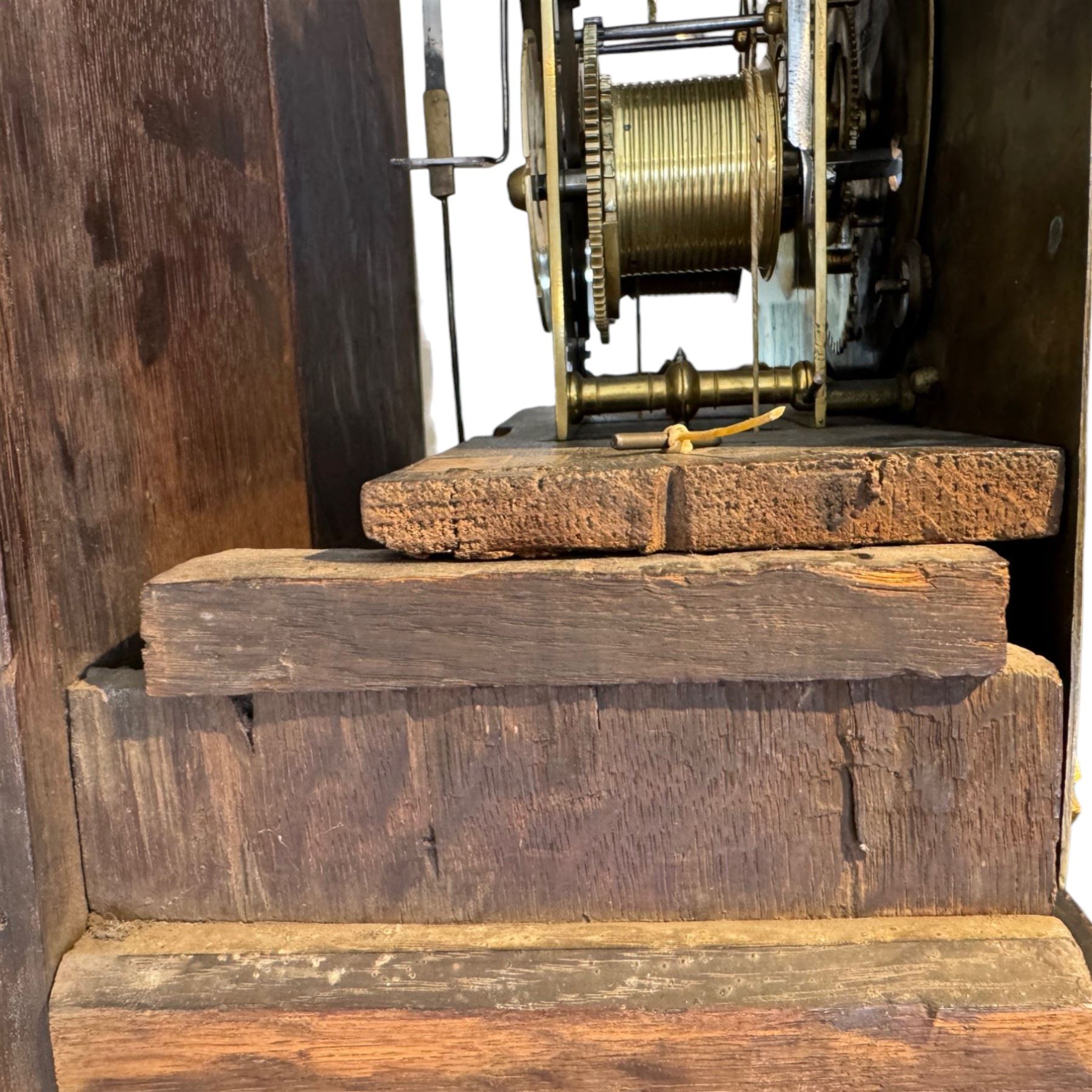 Henry De La Feuille of London-early 18th century marquetry 8-day longcase clock c 1720, hood with a moulded upstand to the domed caddy top, set on a lower upstand above a wide cornice with a marquetry frieze beneath, square hood door with marquetry inlay and attached three-quarter columns with wooden capitals, hood sides with glazed panels, trunk and door inlaid with figural marquetry with various representations of people, birds, scrollwork and foliage, full length door with cock-beading surround and a circular glazed lenticle, the case sides veneered with bordered panels within crossbanded surrounds, plinth with a convex moulding and shallow moulded skirt, brass dial with a matted centre and ringed winding holes, date aperture and seconds dial, silvered chapter with Roman numerals, five minute Arabic’s, minute and inner quarter hour tracks and half-our markers, with pierced steel hands and matching cast scroll spandrels depicting angels supporting a crown, dial pinned directly to a four pillar movement with an outside countwheel and recoil anchor escapement, striking the hours on a cast and polished bell.
With weights, pendulum and key.

Henry De La Feuille was a French Huguenot, born in 1670, moving to Jersey c1690 and finally London where he is thought to have died c1730.
