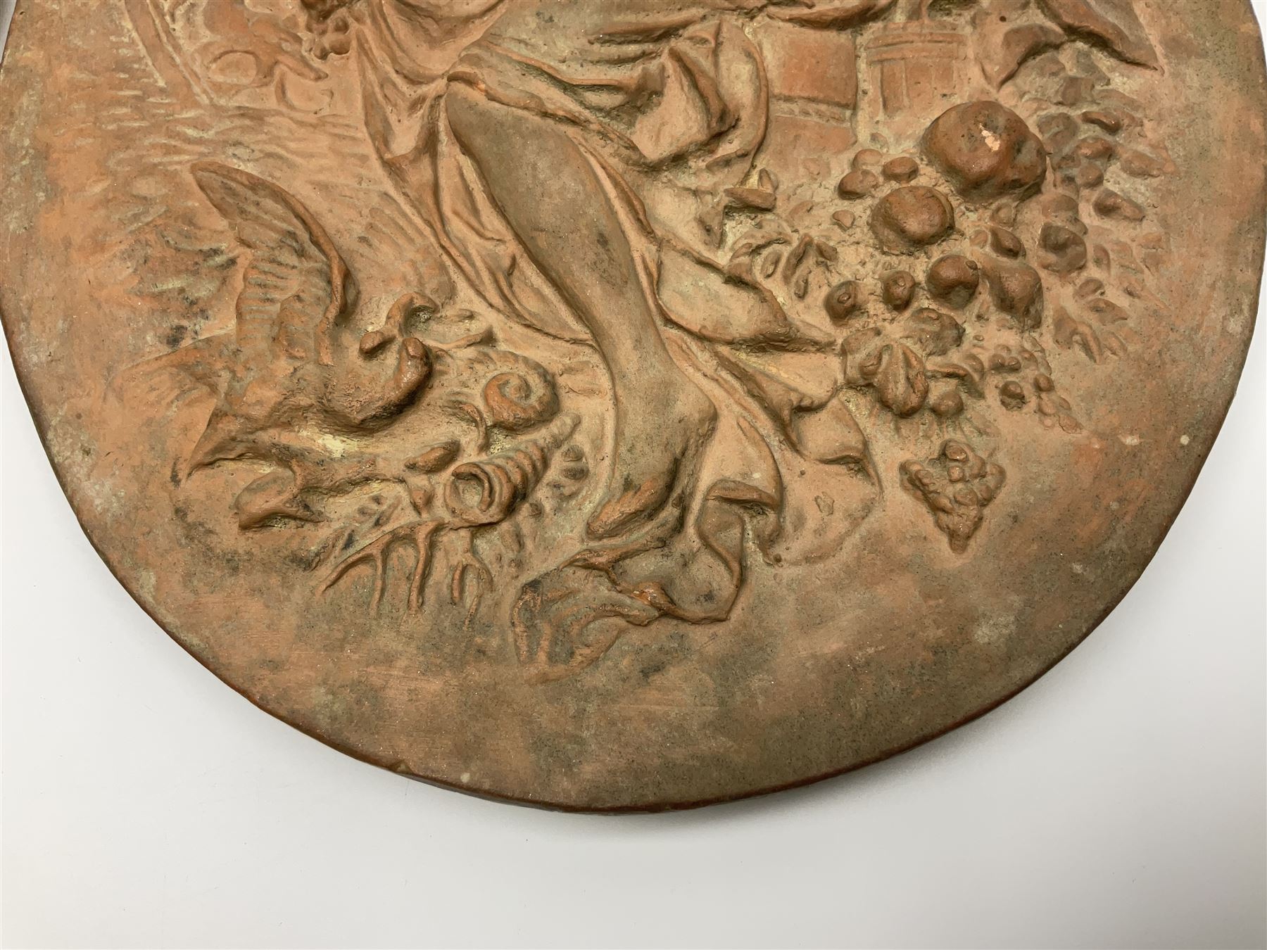 Pair of 19th century classical terracotta relief wall plaques depicting the goddess Hygeia and another goddess, seated holding an ewer, each of oval form, indistinctly signed, each stamped Ferreira verso, H42cm, W30cm