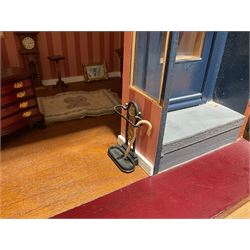 Good quality late 20th century dolls house by M. James dated 1995 in the form of a Beverley East Yorkshire Antique Shop called 'North Bar Antiques'; single-storey single-roomed shop with textured brick walls and flat roof, fully glazed hinged front with recessed hinged customer door and central window to the rear; comprehensively furnished with chests of drawers, pedestal desk, breakfast table, lowboy, two longcase clocks, delft rack with ceramics, occasional tables, pictures, Regency style mirror and collectibles; decorated walls with coving and picture rail and simulated floorboarding; wired for electric lighting; maker's plaque W61cm H42.5cm D41.5cm