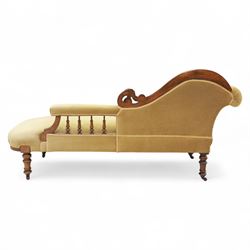 Victorian walnut chaise longue, carved with scrolling acanthus to the end supports and seat rail, upholstered in mustard coloured velvet, shaped and buttoned back and side with turned spindle gallery, raised on short turned legs with ceramic castors 