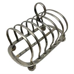 Silver plate seven bar toast rack, of curved form with central ring handle, upon bun feet, H13cm 