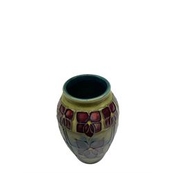 Moorcroft vase of ovoid form decorated in the 'Violet' pattern by Sally Tuffin upon green ground, with painted green mark beneath, H10.5cm