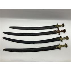 Four Indian tulwar swords; three with cast brass hilts and one with iron hilt; longest blade 81cm; all with scabbards (4)