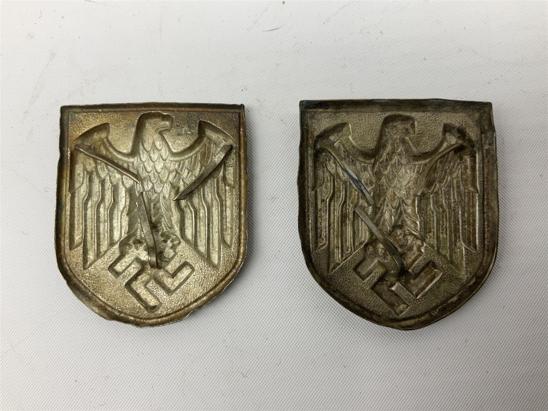 Two WW2 German Army Afrika Korps pith helmet metal side badges; RAD oval metal badge by J.B.u.Co.; WW1 German 1914-1915 bar brooch; and Nienburg War Veteren's Association badge (5)