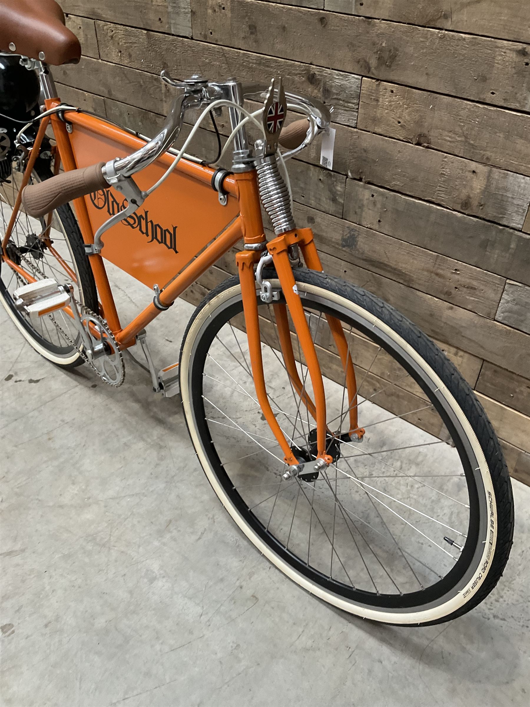 Fully restored vintage advertising bicycle with 2 stroke petrol engine, orange frame, tan leather seat
