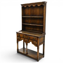 Georgian design oak dresser of small proportions, moulded cornice over open plate rack with two shelves and shaped apron, the base fitted with two drawers over three small drawers, brass drop handles, shaped apron, on square supports united by pot board
