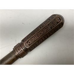 Native war club, the plain circular hardwood shaft with curving end and applied heavy copper tapering octagonal terminal cast with rows of stylised motifs L76cm