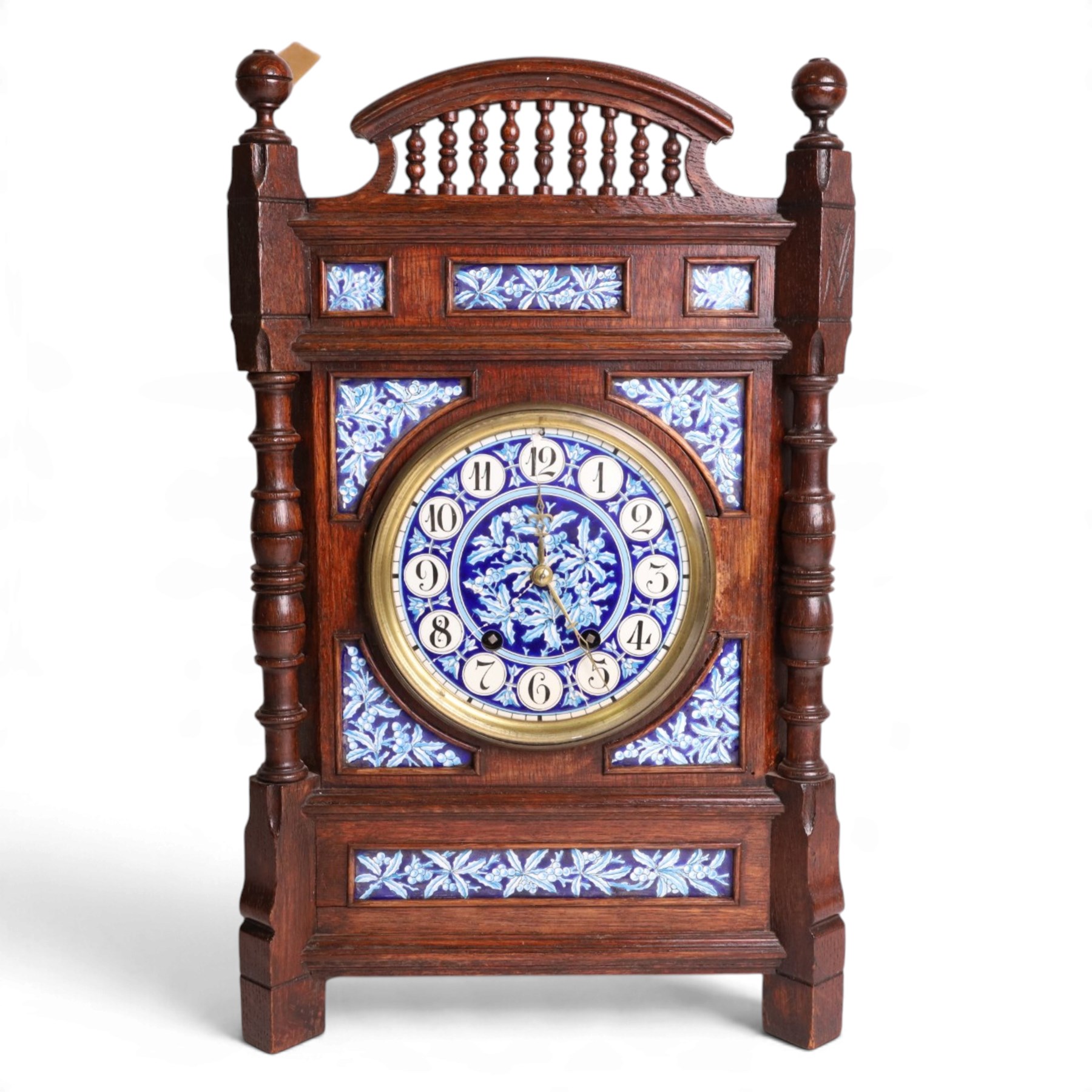 Aesthetic Movement mantel clock, in an oak case with turned detail and ceramic panels decorated with blue and white holly with berries, H48cm