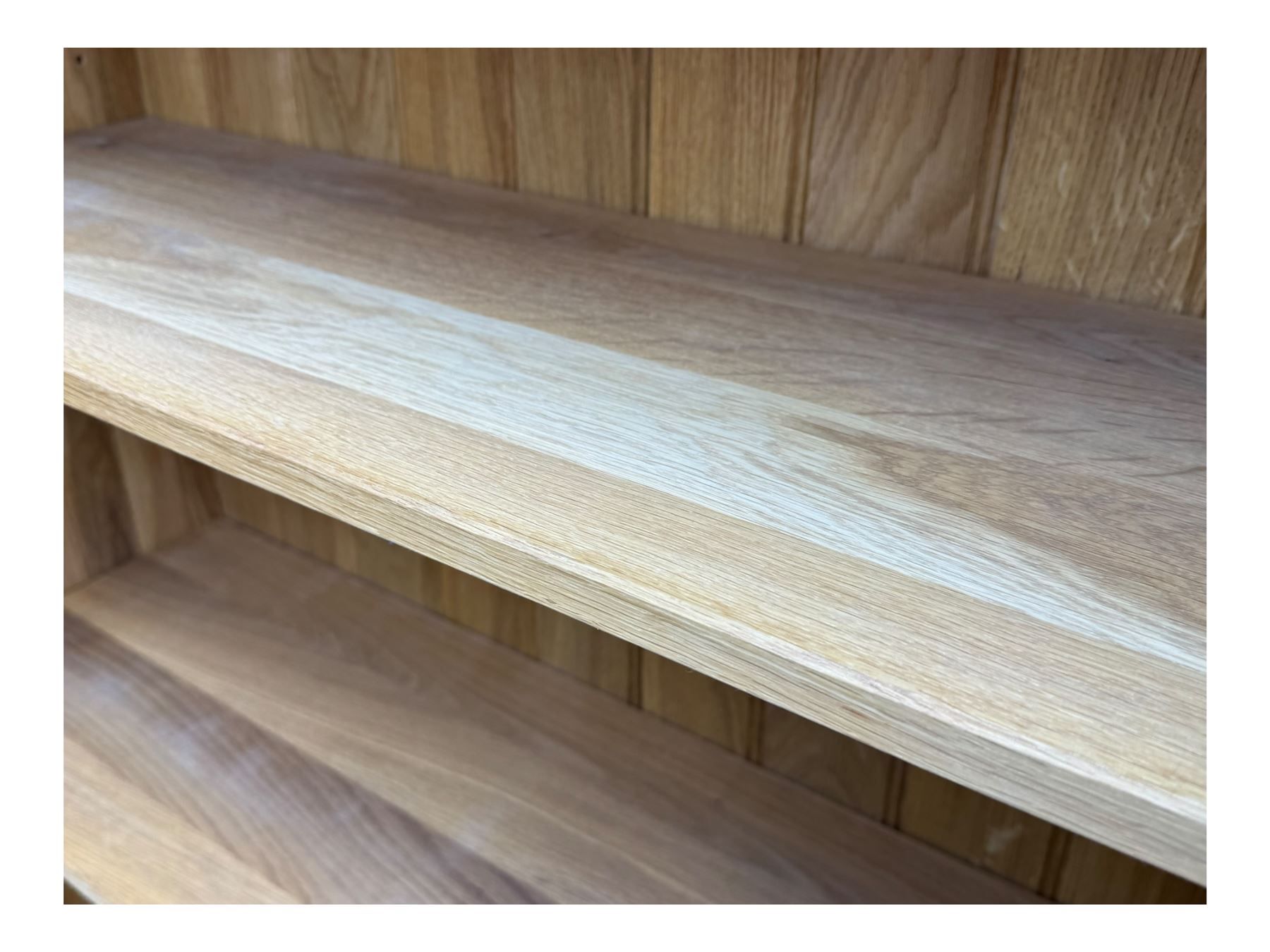 Contemporary light oak open bookcase, rectangular form with projecting top, fitted with five adjustable shelves, on a straight plinth base