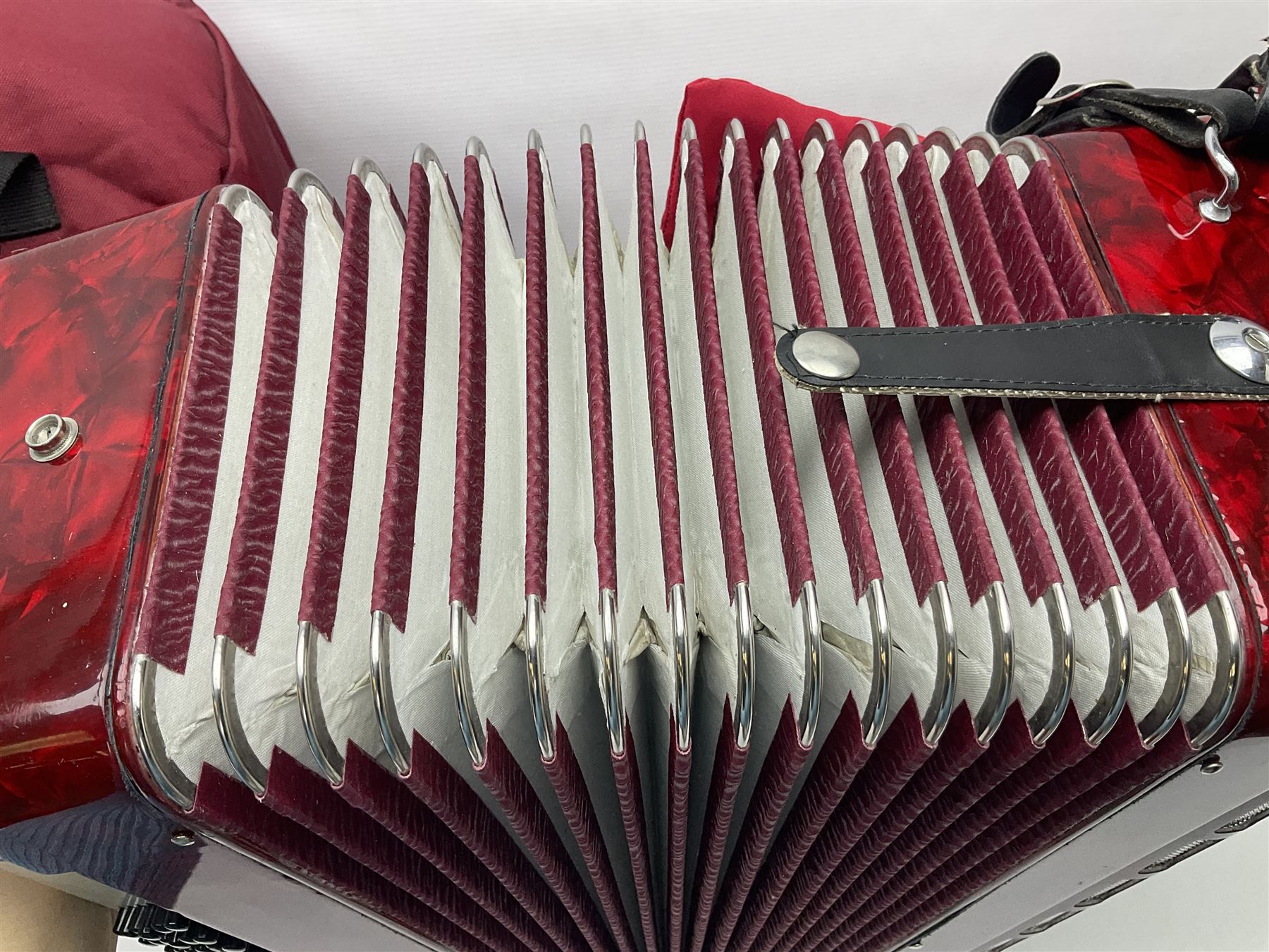 Hsinghai Studio piano accordion with red pearline finish, twenty keys and seventy-two buttons W44cm; in hard carrying case with additional The Music Room soft gig case