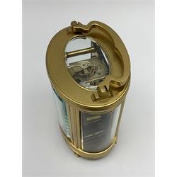 Late 20th century carriage timepiece clock, polished brass case of oval form glazed with bevelled glass panels, white enamel Roman dial signed 'by Collingwood & Sons, Paris', eight day movement, shaped handle