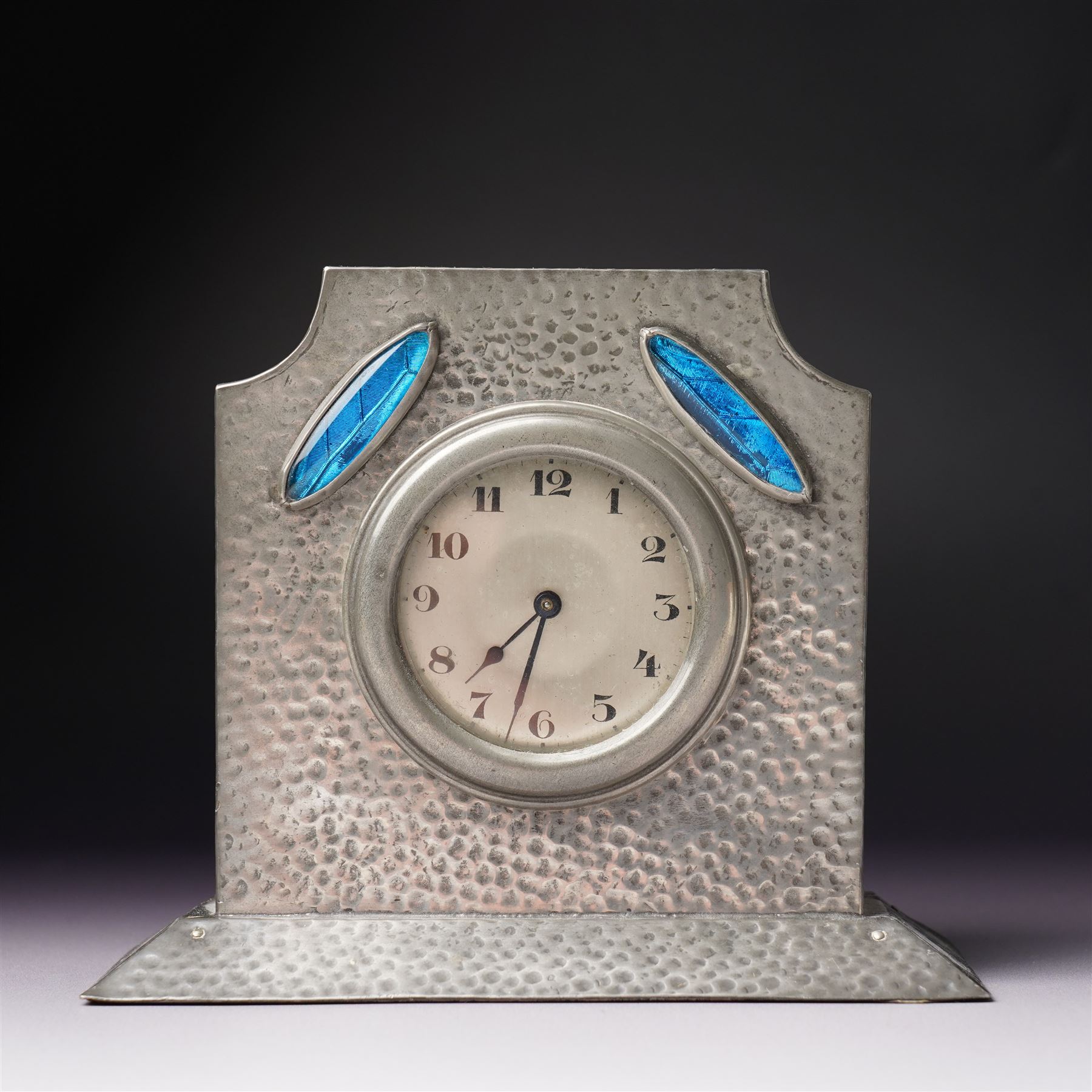Arts and Crafts planished pewter mantel clock, possibly Tudric for Liberty & Co, with inlaid blue enamel in the form of two leaves, apparently unmarked, 11.5cm 
