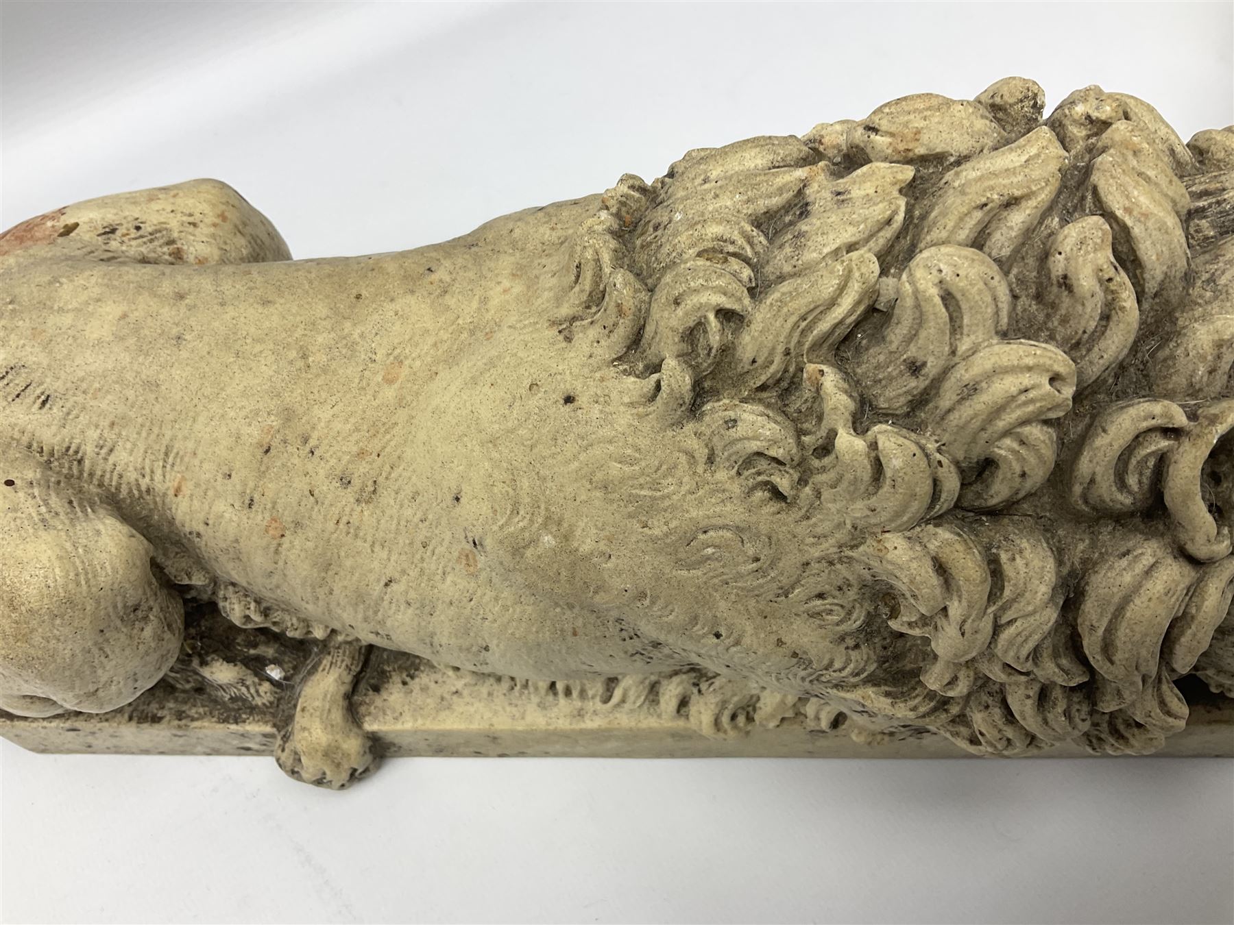 Two early 20th century reconstituted stone Grand Tour or Chatsworth House type lions after Antonio Canova, each modelled in recumbent pose upon a rectangular plinth, signed to plinth Dilettanti, each approximately L31cm