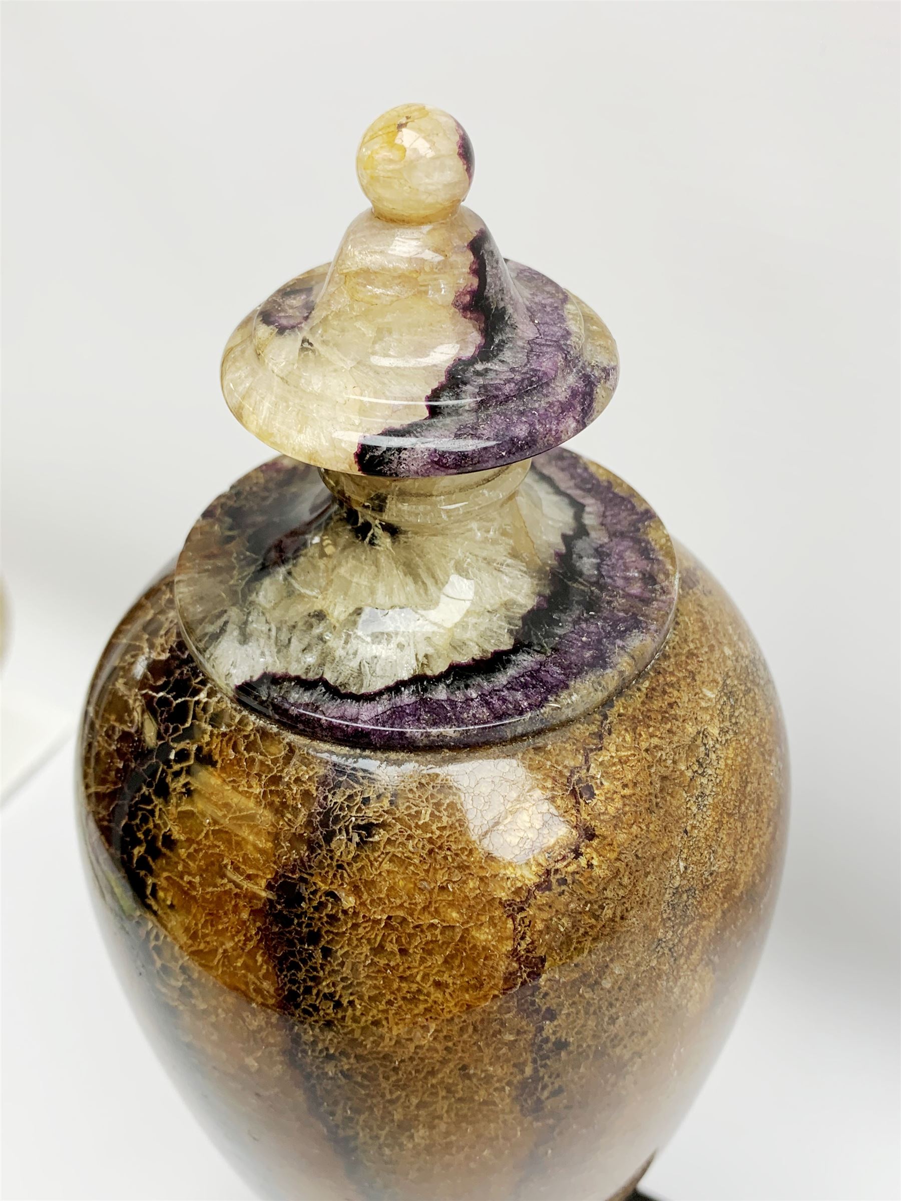 Early 19th century and later Blue John urn, Winnats one vein, of ovoid form with integrated cover and ball finial, upon a spreading circular base, and square stepped black lacquered base, H34.5cm