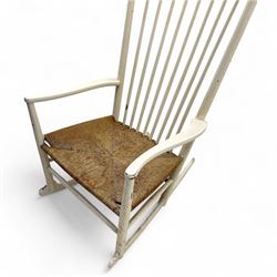 Mid-20th-century Scandinavian painted high-back rocking chair, curved top rail above slender spindle back, shaped arms with rounded ends above hand-woven rush seat, tapered rockers reinforced by turned stretchers 
