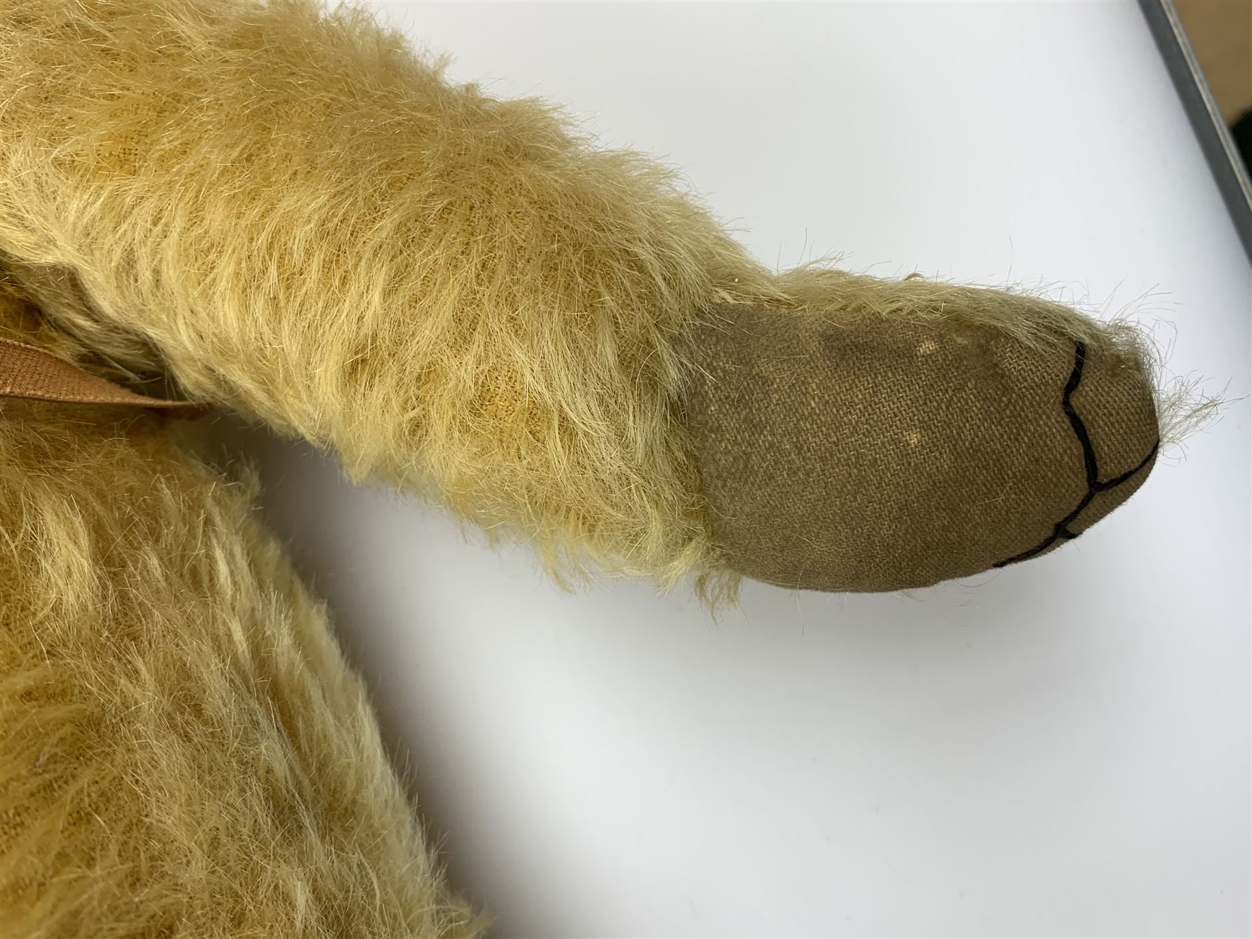 Merrythought Hygienic Toys large 'Magnet' teddy bear c1930s with plush body, swivel jointed head with glass eyes and vertically stitched nose and mouth and jointed limbs,  celluloid wishbone button to right ear and stitched label under right pad H22