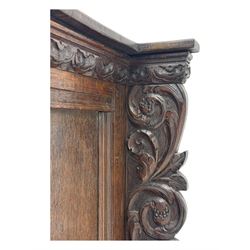 18th century and later carved oak cupboard, enclosed by panelled door carved with central bird motif and scrolled leafage with an outer ebony band, the frieze and uprights carved with repeating lunette and floral designs, flanked by scrolled foliate carved upright brackets