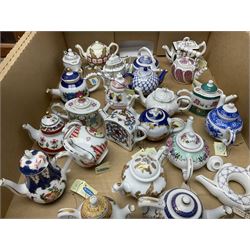 Twenty seven Porcelain Art miniature teapots, with wooden display together with a collection of other ceramics and glassware etc, including Goebel Hummel collectors plates, in three boxes,