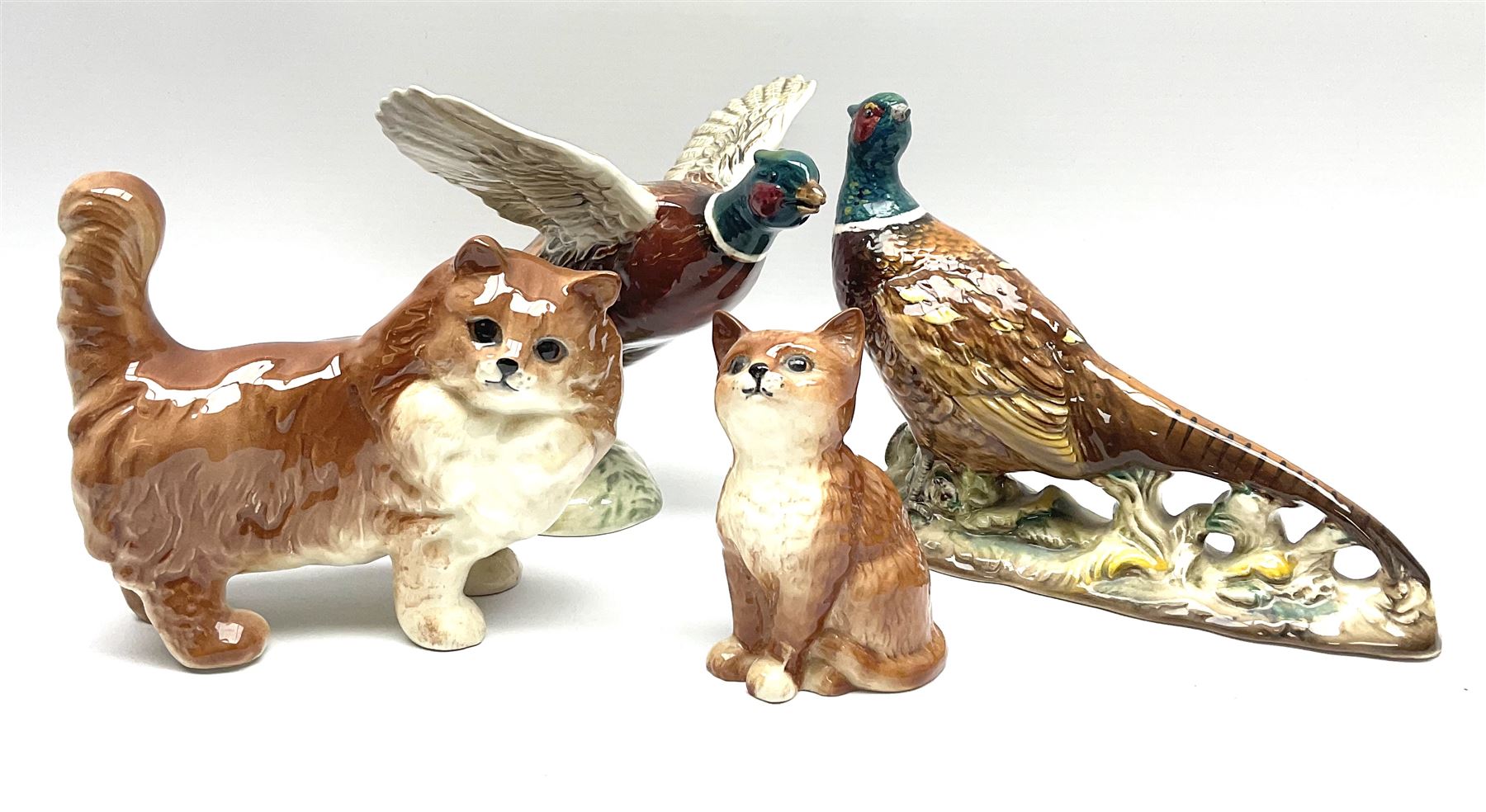 A collection of Beswick figures, comprising ginger cat model no 1898, ginger Persian kitten model no 1886, pheasant in flight model no 849, and pheasant model no 1226b.  