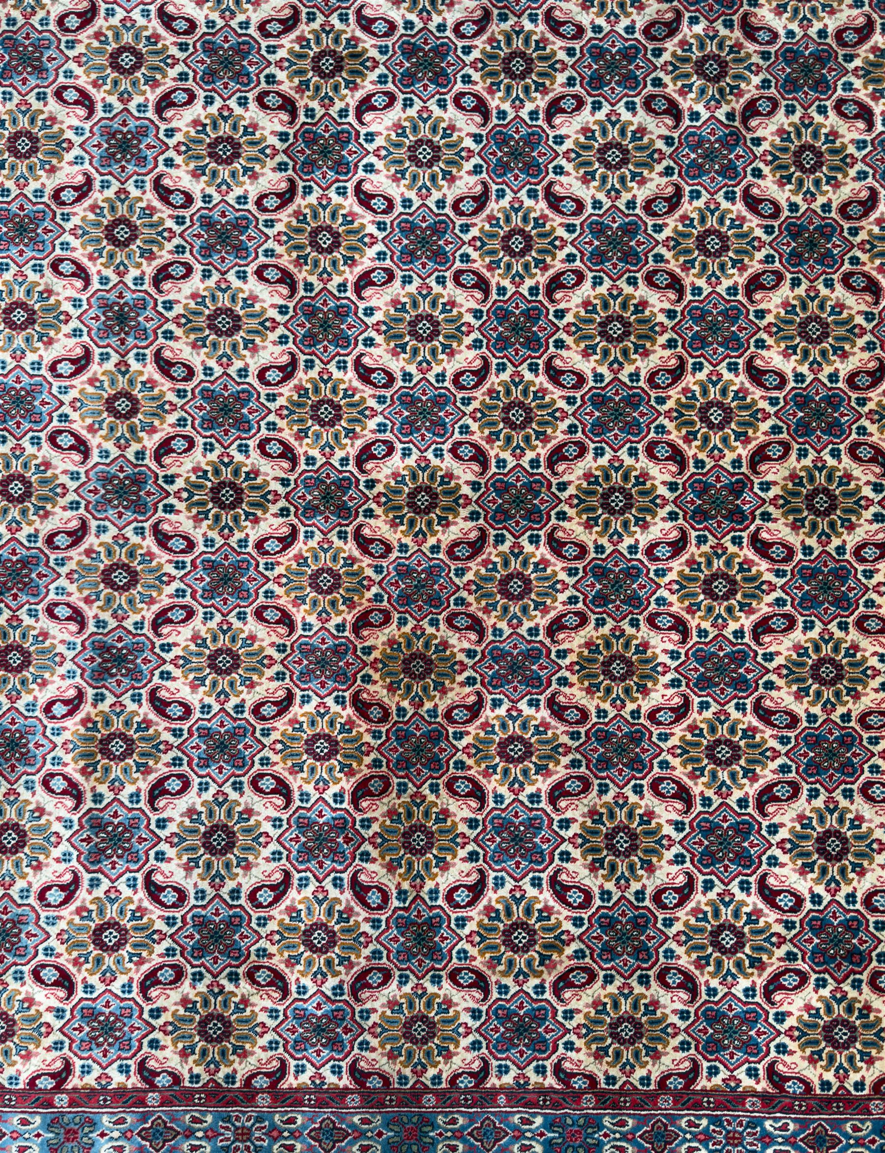Northwestern Persian Hamadan carpet, hand-knotted, ivory field with an all-over Herati design of rosettes and serrated leaves within multiple borders, madder red with angular vine and rosette motifs, 375cm x 271cm 