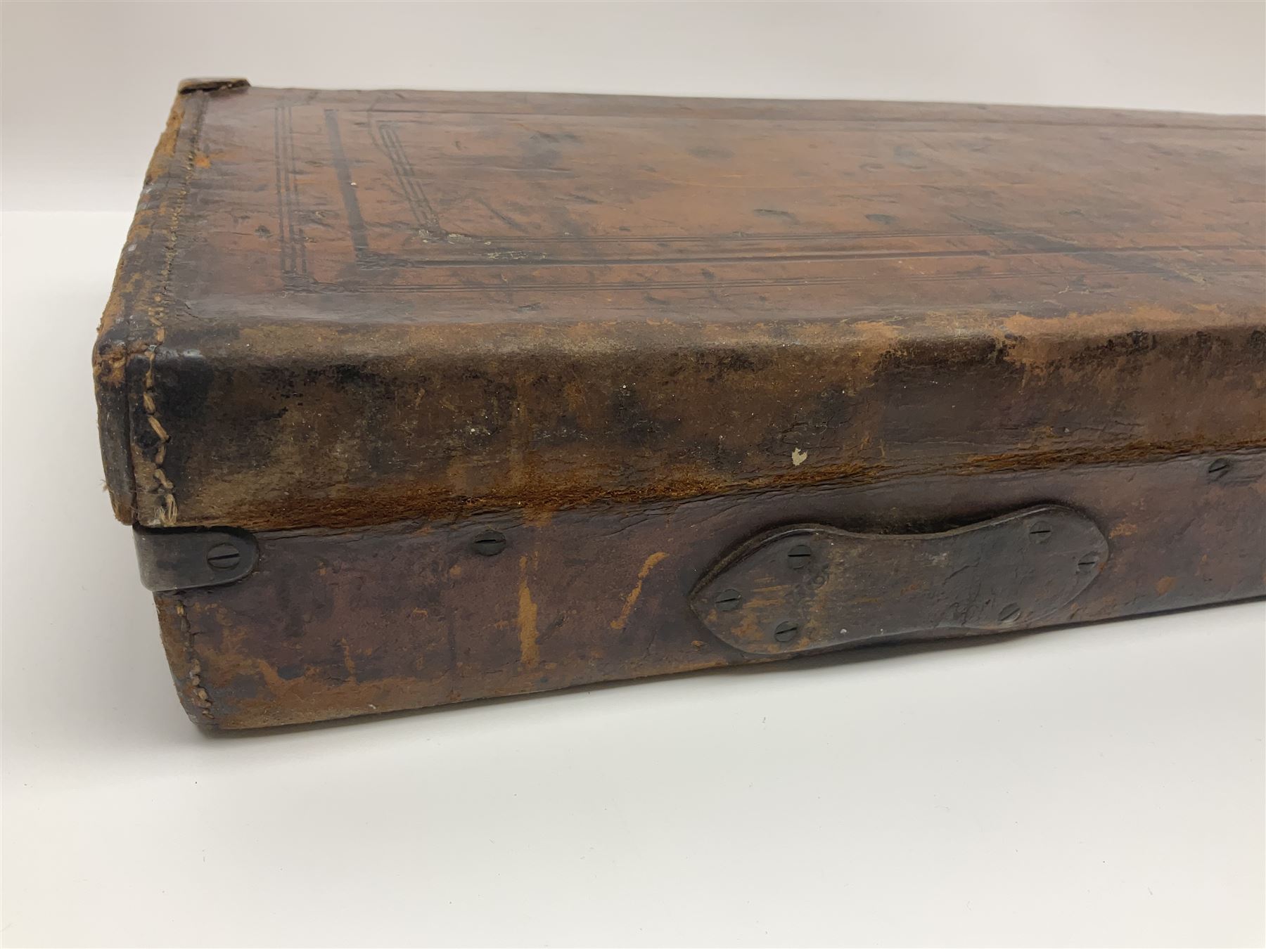 Leather shotgun case, the red baize lined interior with the trade labels of Westley Richards & Co., London, a brass plaque inscribed 'T Nevin, Mirfield, Yorkshire' to cover, with key, case to fit barrel 76cm (30 inches)  
