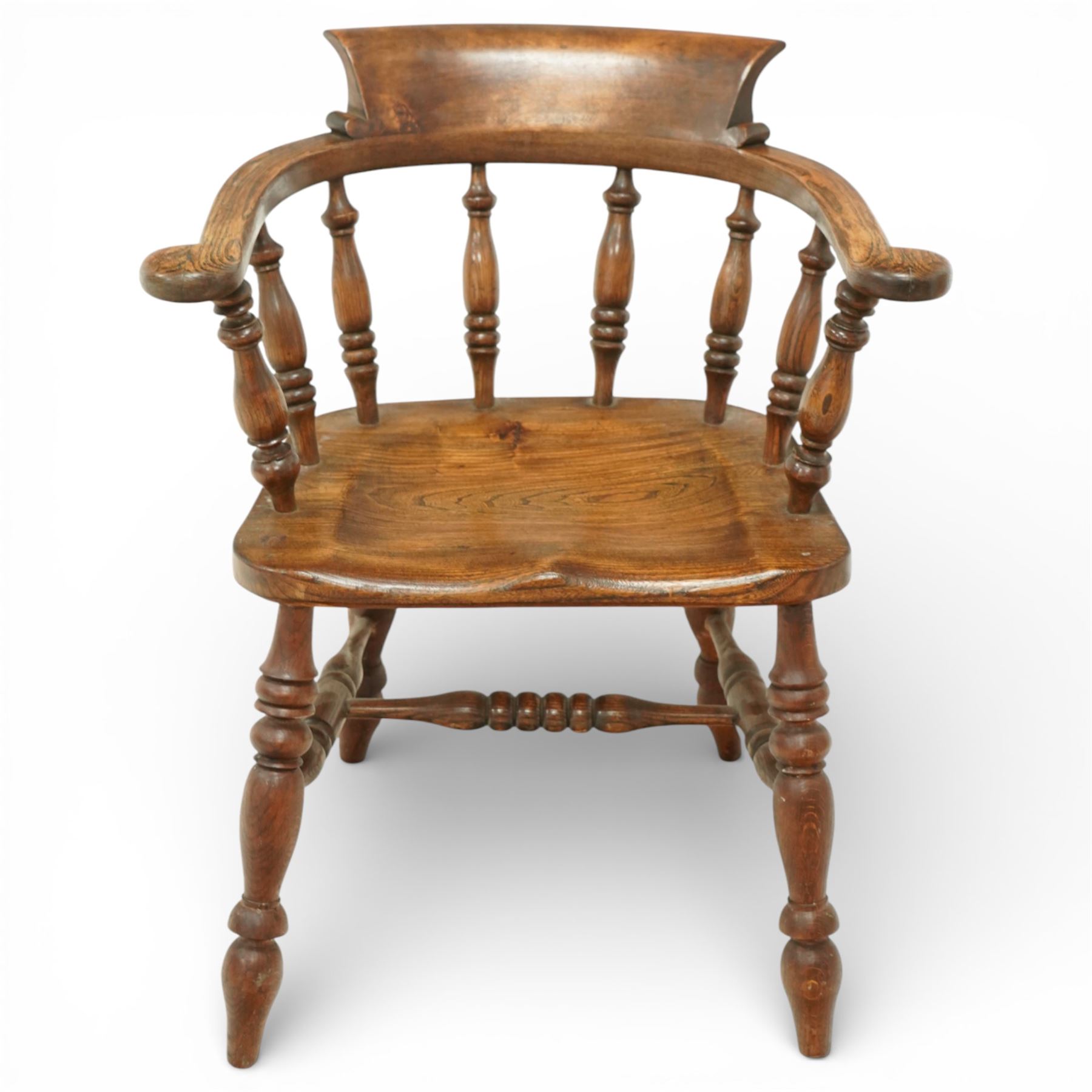 20th century captain’s oak smoker’s chair, with curved horseshoe back rail, turned spindle supports, shaped solid seat, turned legs united by stretchers