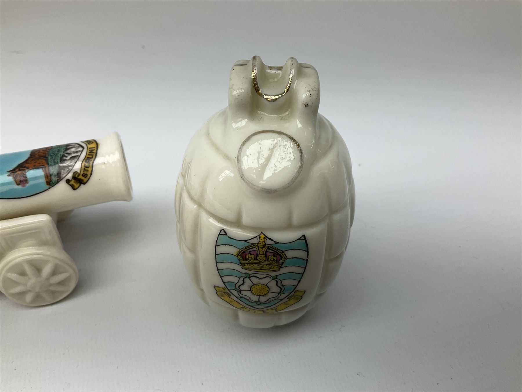 Three pieces of crested ware, comprising grenade detailed 'The Mills Hand Grenade' with Filey Crest, marked beneath Grafton China, a cannon with crest banner detailed 'Sterlini Oppidvm', marked beneath W H Goss, and a submarine with Tunbridge Wells crest, marked beneath Arcadian China 