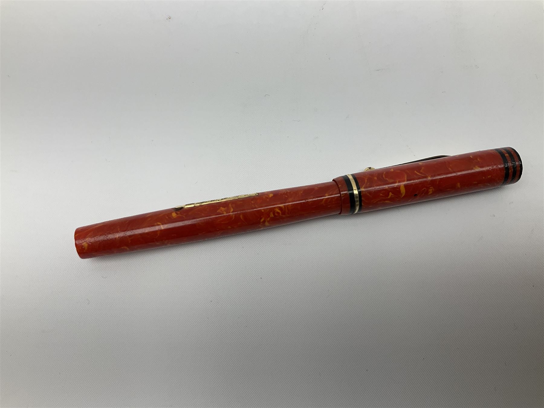 Vintage Swan Mabie Todd lever fill fountain pen in coral red, the nib a/f marked 14K, together with two further vintage Swan Mabie Todd fountain pens, the first example with lever fill, the other leverless, each with black body, one with nib marked 14ct, (3) 