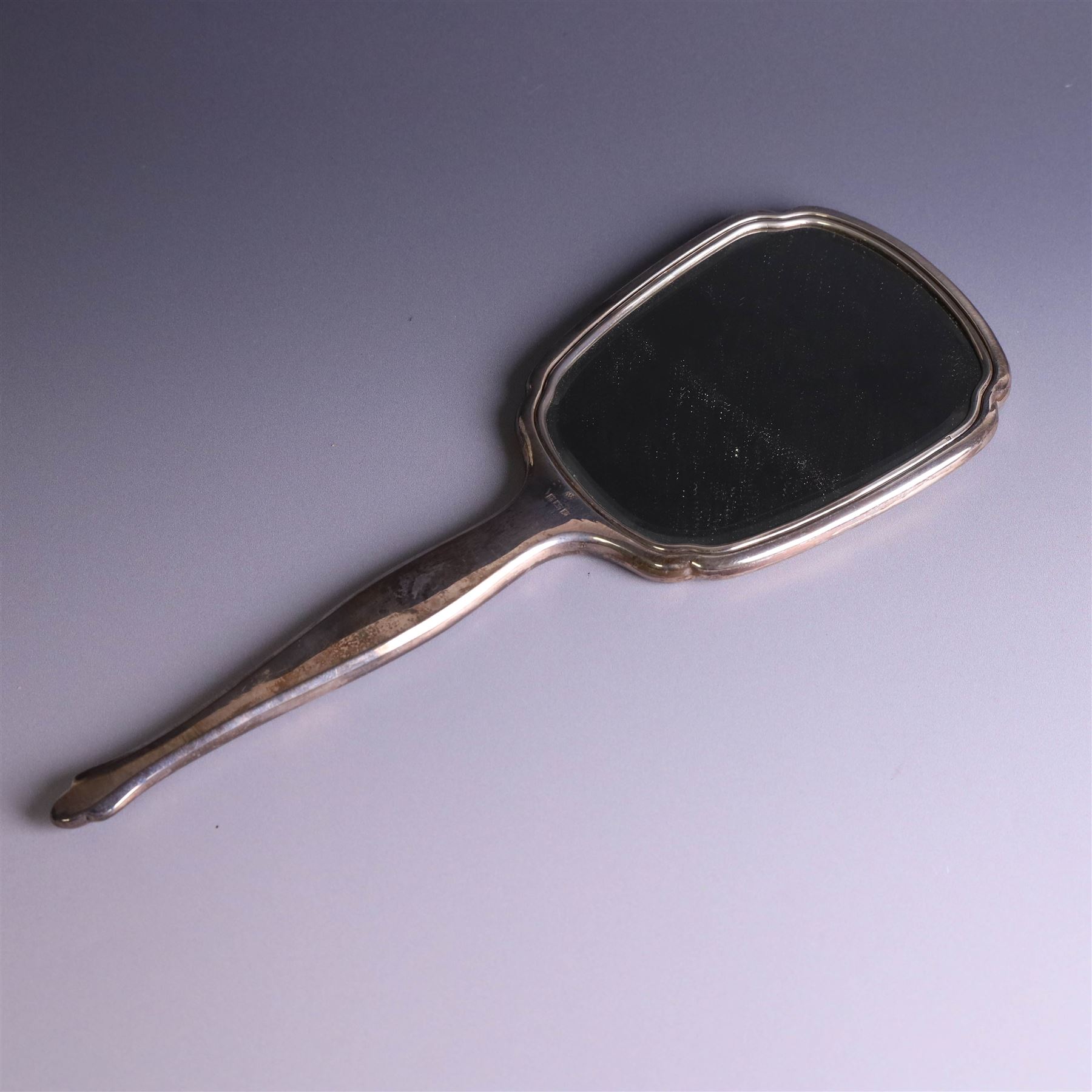 20th Century silver mounted dressing table set, comprising hand mirror, clothes brush, hairbrush and comb holder, each with engine turned and engraved floral decoration, three pieces hallmarked Adie Brothers Ltd Birmingham 1964, the comb holder hallmarked Elkington & Co Ltd Birmingham 1965, contained within a fitted tooled leather case