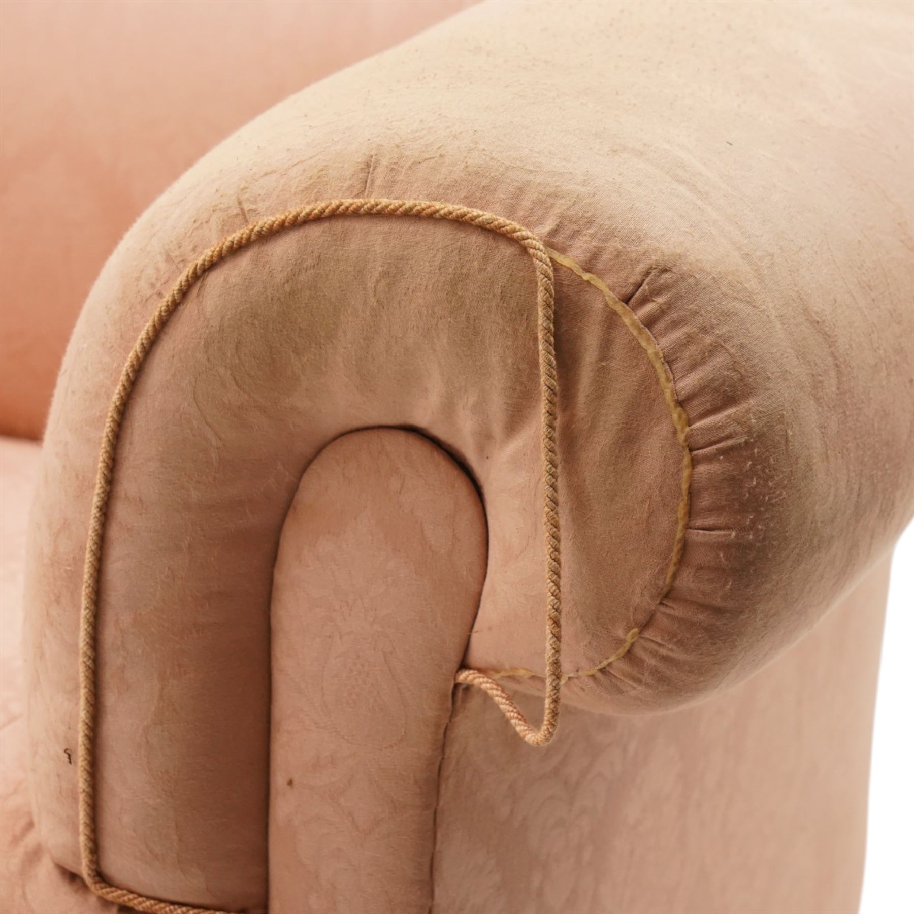 Victorian two seat sofa, upholstered in pink fabric, bowed form with scroll back and arms, raised on turned legs with castors